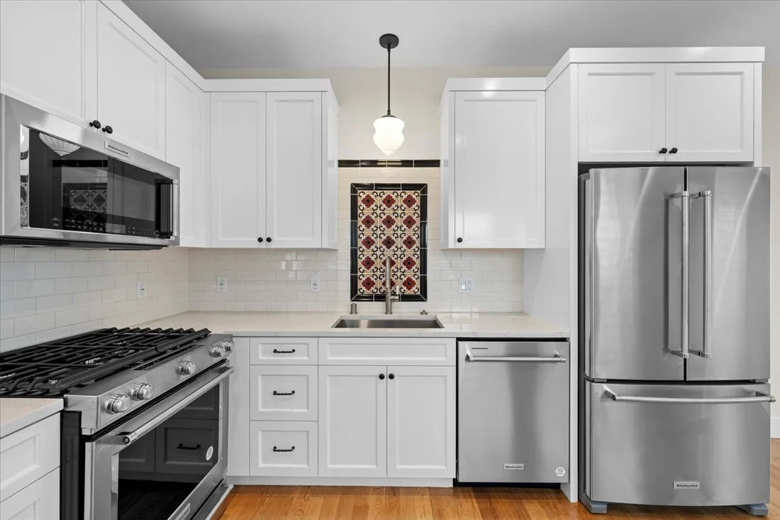 White shaker cabinetry with a decorative tile backsplash accent and stainless appliances in a Torrance neighborhood kitchen.